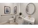 Cozy bathroom featuring a pedestal sink, toilet, and decorative artwork at 1132 Moss Cove Ct, Port Charlotte, FL 33953