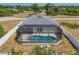 Aerial view of a screened-in pool and fenced backyard providing a private oasis at 118 Boxwood Ln, Rotonda West, FL 33947