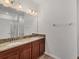 Bathroom with double sink vanity, granite countertop, and large mirror at 118 Boxwood Ln, Rotonda West, FL 33947