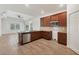 Well-lit kitchen with tile floors, brown wood cabinets, granite countertops, stainless steel appliances, and an eat-in island at 118 Boxwood Ln, Rotonda West, FL 33947