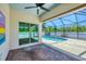 Covered patio featuring brick pavers, ceiling fan, and view of the screened-in pool at 118 Boxwood Ln, Rotonda West, FL 33947