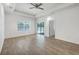 Bright living room features wood-look tile flooring, a ceiling fan, and sliding doors to a screened-in porch at 118 Boxwood Ln, Rotonda West, FL 33947