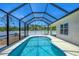 Screened-in pool view features metal ladder and long swimming area at 118 Boxwood Ln, Rotonda West, FL 33947