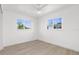 Bright bedroom featuring wood-look floors, ceiling fan, and two large windows at 124 Rotonda Cir, Rotonda West, FL 33947