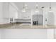 A bright kitchen features white cabinets, a granite countertop, stainless steel appliances, and modern pendant lighting at 124 Rotonda Cir, Rotonda West, FL 33947