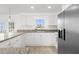 Well-lit kitchen boasts white cabinetry, granite countertops, stainless steel appliances, and a stylish design at 124 Rotonda Cir, Rotonda West, FL 33947