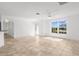 Bright living room featuring tile flooring, a ceiling fan, and large windows that provide natural light at 124 Rotonda Cir, Rotonda West, FL 33947