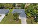 Aerial view of single-story home with an attached two-car garage, surrounded by greenery and adjacent properties at 1275 Huntington St, North Port, FL 34288