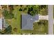 Overhead shot of a well-maintained property with gray roof, set amidst lush greenery, pool visible on neighboring lot at 1275 Huntington St, North Port, FL 34288