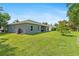 View of the home exterior from the backyard, showcasing the grassy space and home design at 1275 Huntington St, North Port, FL 34288