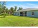 Exterior view of the home featuring a spacious, green backyard at 1275 Huntington St, North Port, FL 34288