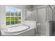 Bright bathroom featuring a large soaking tub, a glass shower and a large window at 1275 Huntington St, North Port, FL 34288
