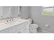 Bright bathroom with a white sink, cabinets and toilet, complemented by a large mirror at 1275 Huntington St, North Port, FL 34288
