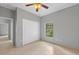 A clean bedroom features a ceiling fan, closet, and window overlooking the outdoors at 1275 Huntington St, North Port, FL 34288