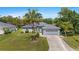 Well-manicured lawn complements this single-story home, complete with an attached two-car garage and lush landscaping at 1275 Huntington St, North Port, FL 34288