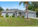 Charming single-story home with a well-manicured lawn, gray exterior, and attached two-car garage at 1275 Huntington St, North Port, FL 34288