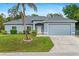 Charming single-story home with a well-maintained lawn, beautiful shrubbery, and a two-car garage at 1275 Huntington St, North Port, FL 34288