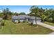 Desirable single-story home featuring a manicured lawn, complemented by shrubbery and an attached two-car garage at 1275 Huntington St, North Port, FL 34288