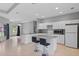 Open kitchen area featuring a center island with bar stools, white cabinets, and modern appliances at 1275 Huntington St, North Port, FL 34288