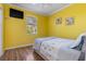 This bedroom features bright yellow walls, wood floors and a mounted TV at 1313 Wise Dr, North Port, FL 34286