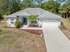 Well-maintained home with a concrete driveway, two-car garage, and landscaped front yard at 1313 Wise Dr, North Port, FL 34286