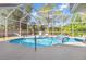 Beautiful screened-in pool area with a spa, lounge chairs, and plenty of green space at 1313 Wise Dr, North Port, FL 34286