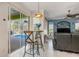 Inviting living space with a view of the screened pool, charming bar seating, and an accent wall at 1313 Wise Dr, North Port, FL 34286