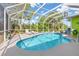 Inviting screened-in pool and spa surrounded by lush landscaping and clear blue skies at 1313 Wise Dr, North Port, FL 34286