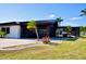 View of the backyard featuring a screened in patio area, waterfront, and tropical landscaping at 148 Peckham St Se, Port Charlotte, FL 33952
