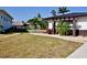 Landscaped backyard featuring waterfront canal, well-maintained lawn, and tropical foliage at 148 Peckham St Se, Port Charlotte, FL 33952