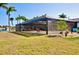 Screened-in lanai overlooking lush yard, palm trees and waterfront canal at 148 Peckham St Se, Port Charlotte, FL 33952