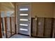 Entry way with modern, glass-paneled door amid exposed studs at 148 Peckham St Se, Port Charlotte, FL 33952