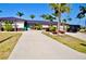 Charming home featuring a large driveway, tropical landscaping, and a unique dark metal roof at 148 Peckham St Se, Port Charlotte, FL 33952
