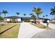 Attractive single-story home with a well-manicured lawn, mature palm trees, and a long driveway at 148 Peckham St Se, Port Charlotte, FL 33952