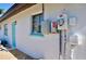 Side view of home showcasing a blue door, window with matching trim, and utility meters at 148 Peckham St Se, Port Charlotte, FL 33952