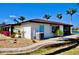 Exterior view shows home with blue door, metal roof, tropical landscaping and an HVAC unit at 148 Peckham St Se, Port Charlotte, FL 33952