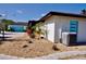 Exterior view shows home with blue door, metal roof, tropical landscaping and an HVAC unit at 148 Peckham St Se, Port Charlotte, FL 33952