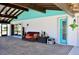 Inviting outdoor patio featuring comfortable seating, a ceiling fan, and a beautifully painted blue door at 148 Peckham St Se, Port Charlotte, FL 33952
