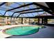 Screened-in pool area featuring a swimming pool and lounge chairs with waterfront views and outdoor dining at 148 Peckham St Se, Port Charlotte, FL 33952