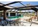 Outdoor patio featuring an in-ground pool, dining, and lounge area for relaxing and enjoying the outdoors at 148 Peckham St Se, Port Charlotte, FL 33952