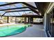 Screened-in patio featuring a pool, lounge chairs, and outdoor dining space at 148 Peckham St Se, Port Charlotte, FL 33952