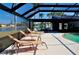 Screened-in pool area featuring a swimming pool and lounge chairs with waterfront views at 148 Peckham St Se, Port Charlotte, FL 33952