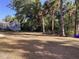 A spacious backyard with mature trees, a storage shed, and partial fencing, offering ample space for recreation at 1488 Squaw Ln, North Port, FL 34286