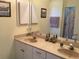 Bathroom featuring dual sinks, a vanity, and a shower-tub combination with a curtain at 1488 Squaw Ln, North Port, FL 34286