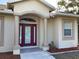 Inviting front entrance with elegant columns, a security camera, and tasteful landscaping at 1488 Squaw Ln, North Port, FL 34286