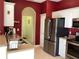 Kitchen with stainless steel appliances, neutral countertops, and red accent wall at 1488 Squaw Ln, North Port, FL 34286