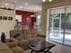 Relaxing living room with a beige sofa, open floor plan, and screened patio access at 1488 Squaw Ln, North Port, FL 34286