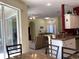 Open-concept living room with kitchen island, ceiling fan, and sliding glass doors to screened patio at 1488 Squaw Ln, North Port, FL 34286