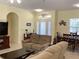 Comfortable living room with a sofa, TV, view of the dining area, and front entryway at 1488 Squaw Ln, North Port, FL 34286