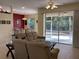 Comfortable living room with a beige sofa, adjacent dining area, and a screened patio at 1488 Squaw Ln, North Port, FL 34286